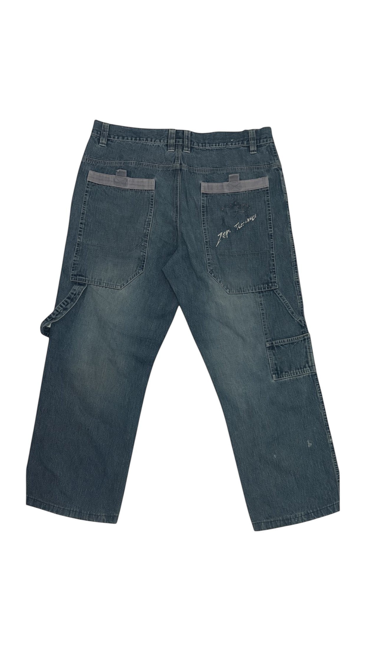 SohoStich Co. medium wash denim carpenter pants with utility pockets and grey back pocket accents.